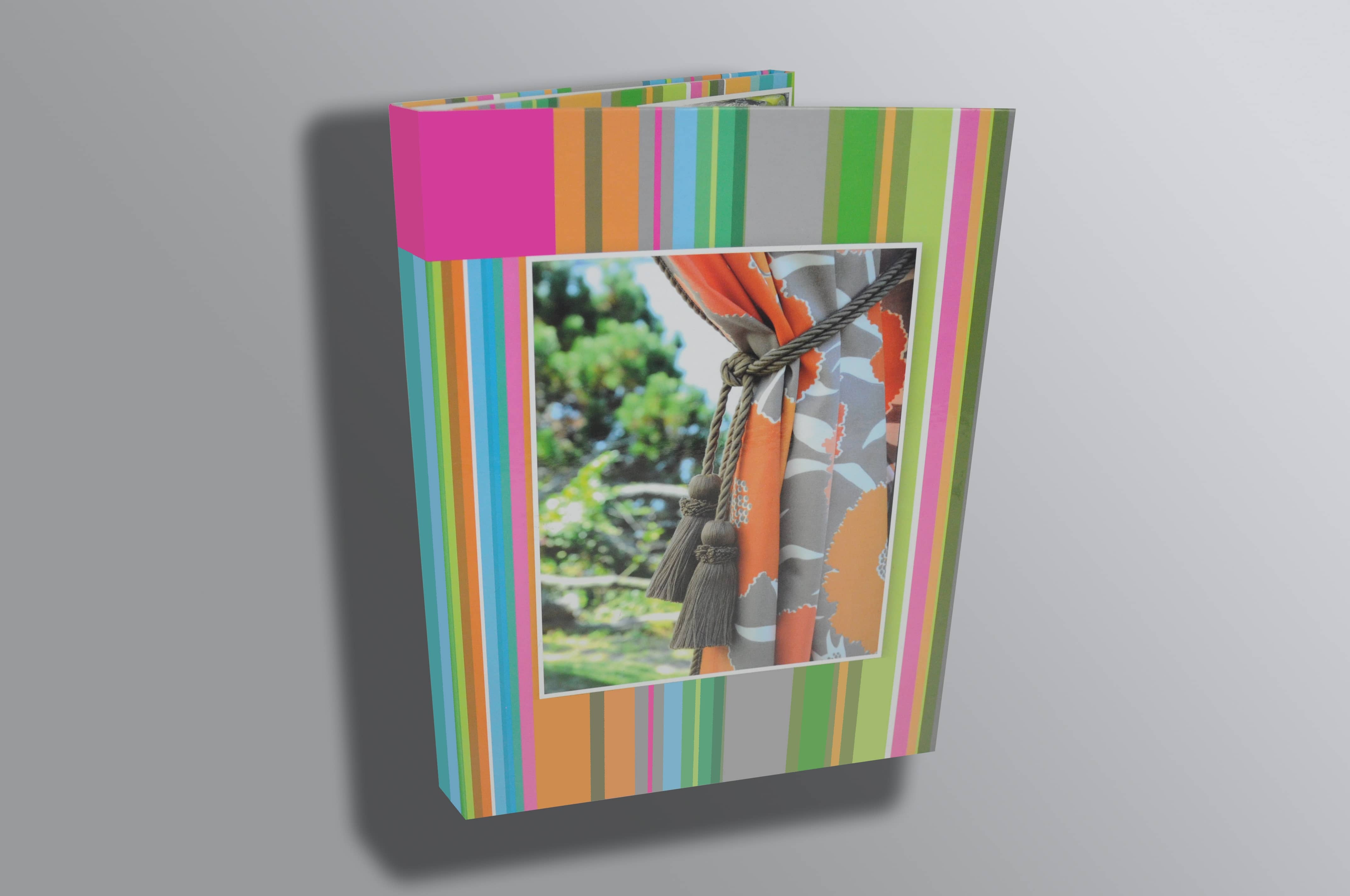 Colorful striped display binder with am image of a colorful curtain pulled back with a rope tie